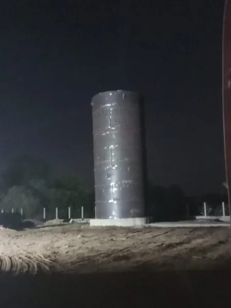 Vertical fabricated vessel at night